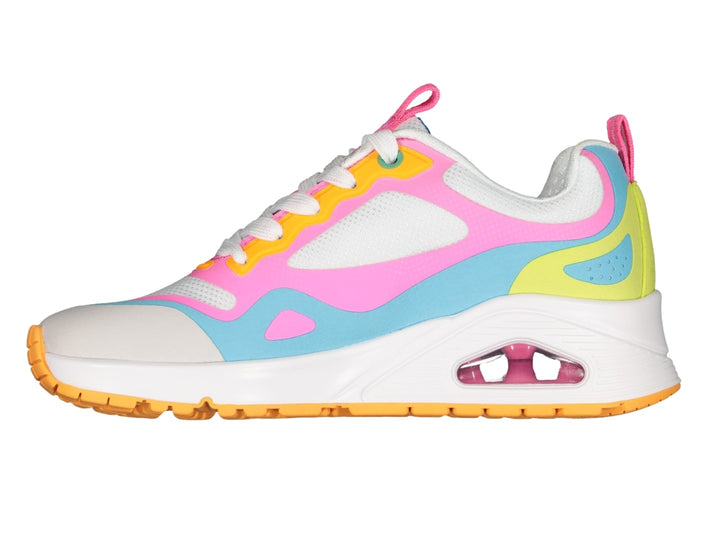 Tenis deportivos Skechers multicolores en blanco, rosa, azul y amarillo con suela blanca y amortiguador transparente.