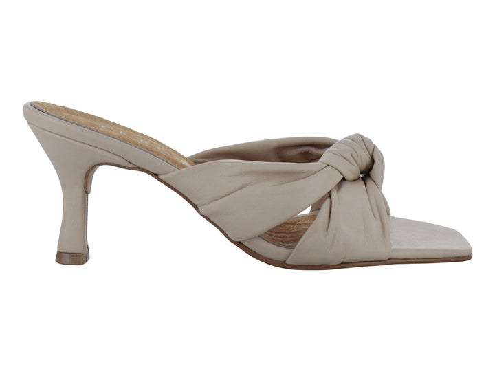 Sandalia mule color hueso con tacón y detalle de nudo frontal.