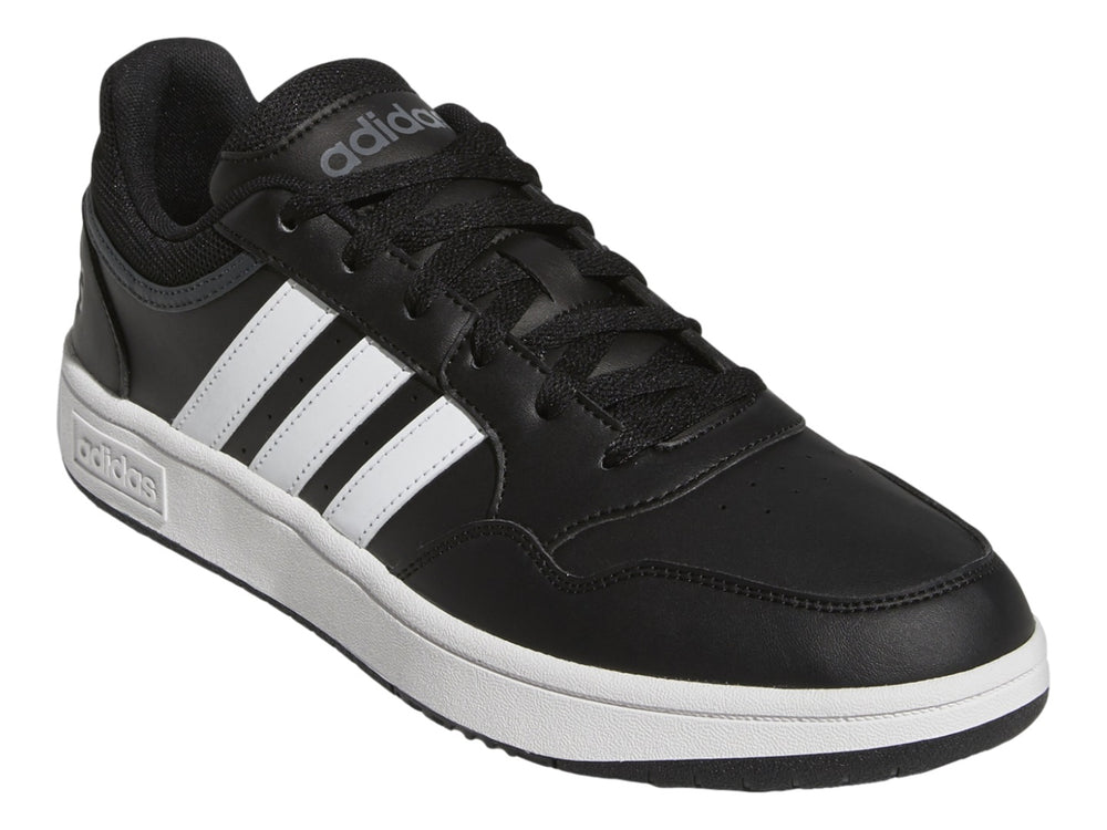 Tenis Adidas color negro con franjas blancas y suela blanca.