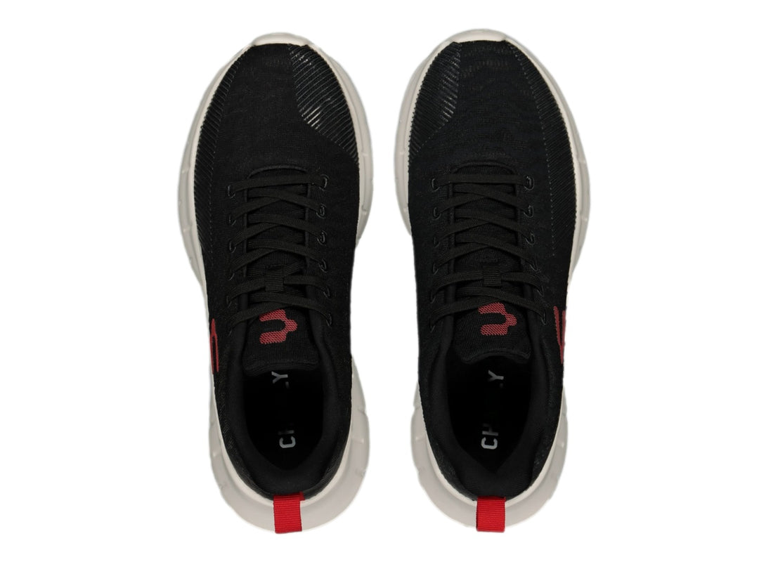 Tenis deportivos Charly color negro con suela blanca y detalles en rojo.