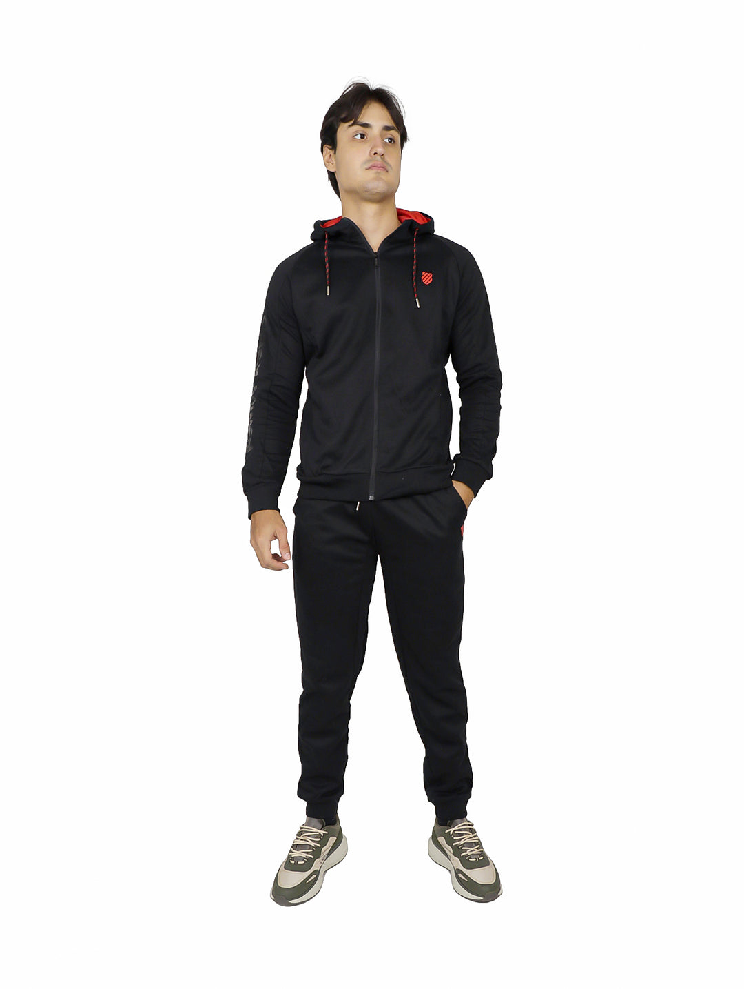 Hombre vistiendo pantalón deportivo negro K-Swiss con sudadera a juego sobre fondo blanco.