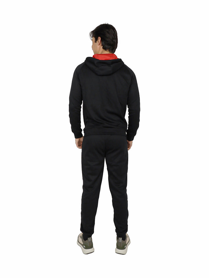Hombre vistiendo pantalón deportivo negro K-Swiss con sudadera a juego sobre fondo blanco.