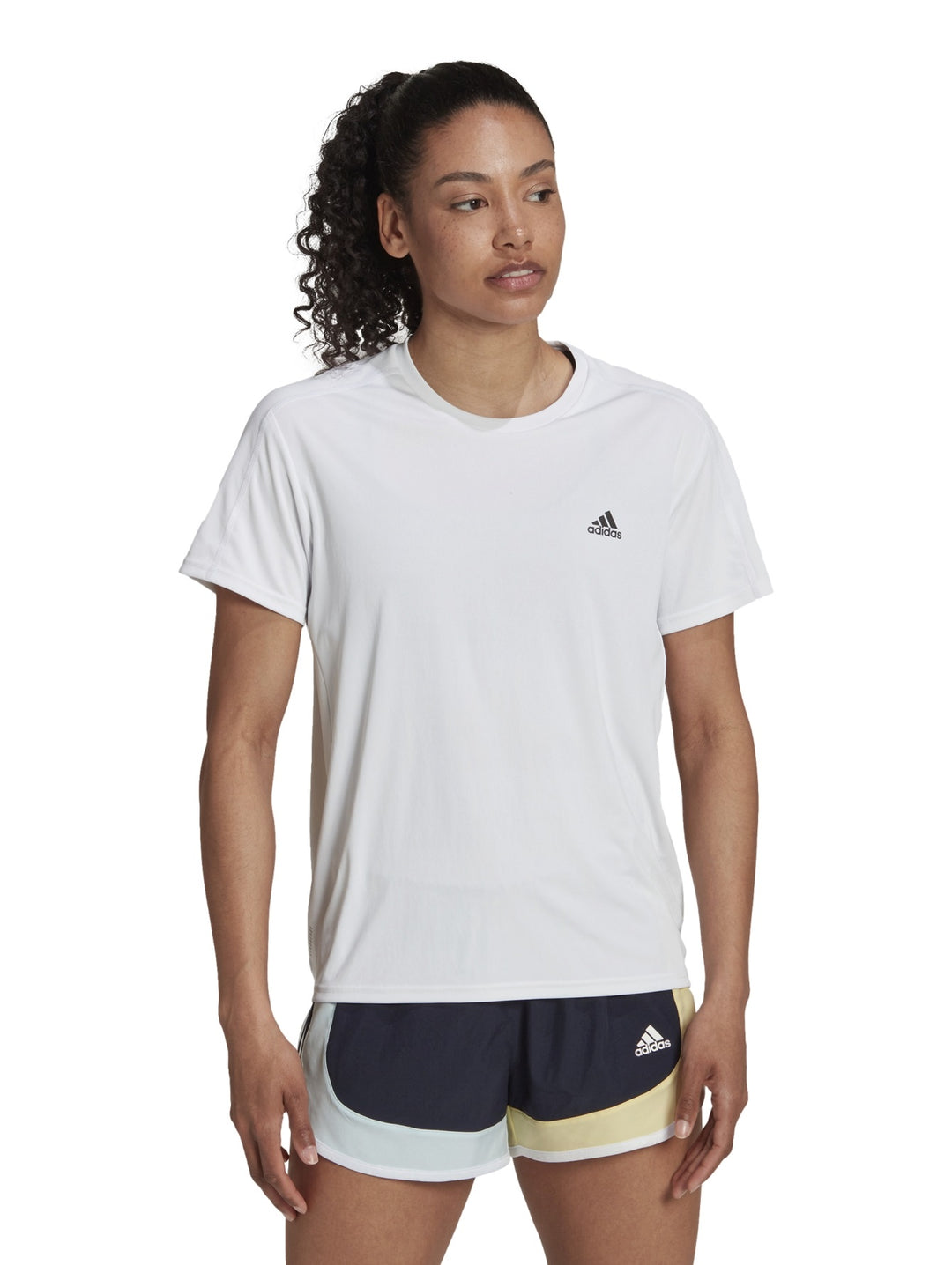 Mujer vistiendo una camiseta deportiva blanca de manga corta marca Adidas.