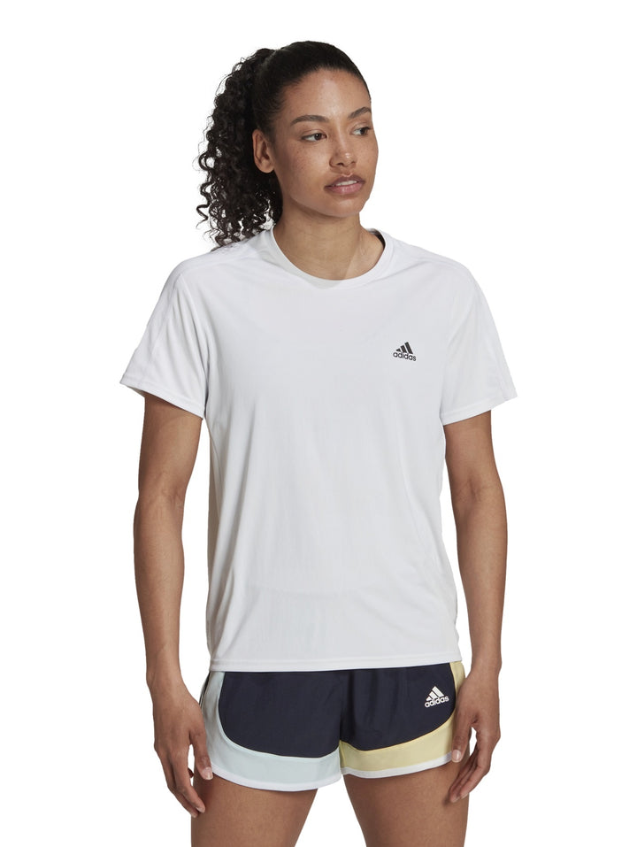 Mujer vistiendo una camiseta deportiva blanca de manga corta marca Adidas.
