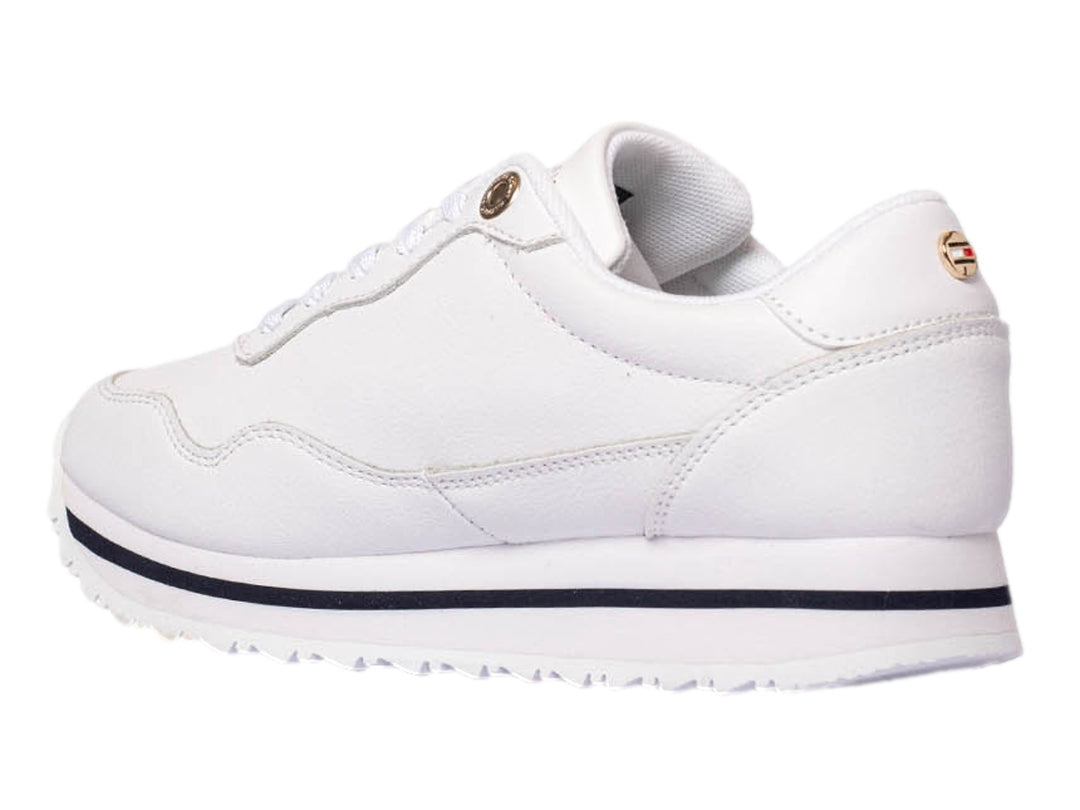 Tenis Tommy Hilfiger blancos con franja lateral en azul, blanco y rojo y suela blanca.