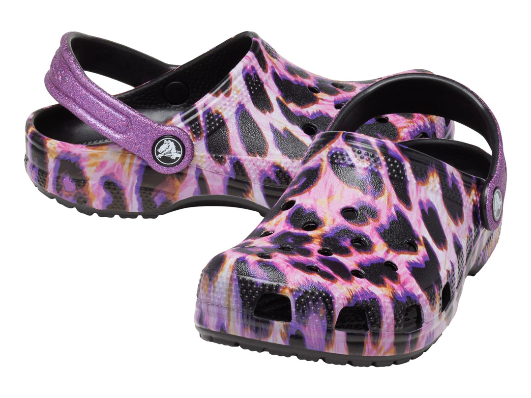 Zuecos Crocs con estampado de leopardo en tonos morados y negros, con correa trasera ajustable.
