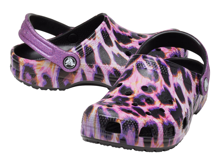 Zuecos Crocs con estampado de leopardo en tonos morados y negros, con correa trasera ajustable.
