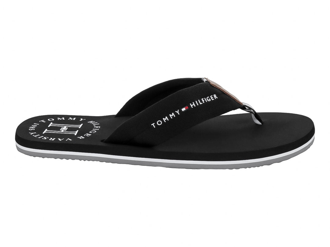 Sandalia negra tipo flip-flop de Tommy Hilfiger con suela blanca y detalles en blanco.
