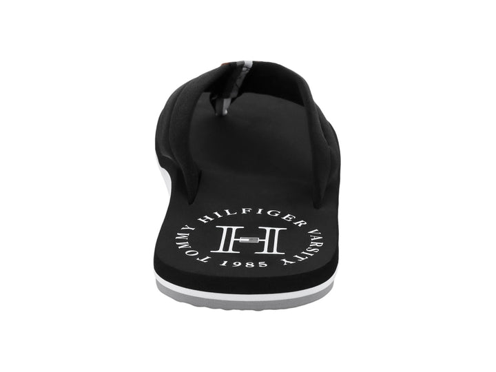 Sandalia negra tipo flip-flop de Tommy Hilfiger con suela blanca y detalles en blanco.