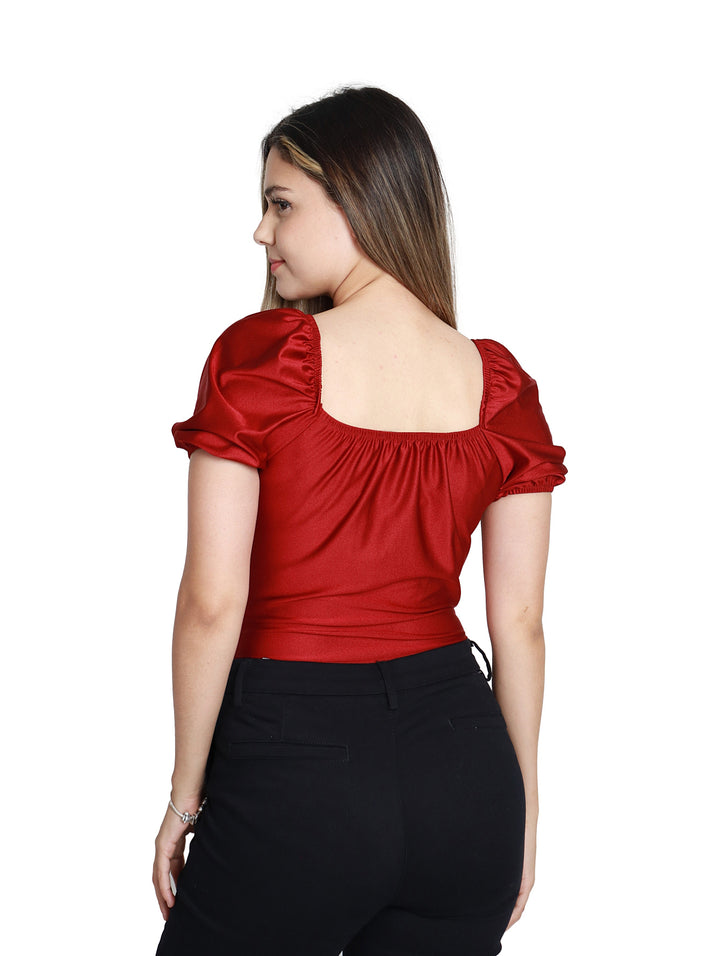 Mujer vistiendo blusa color vino con cuello en V y pantalones negros.