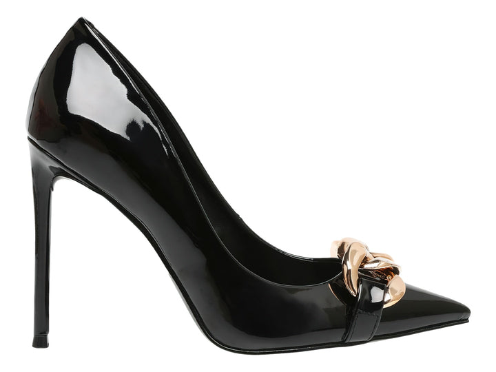 Zapato de tacón alto negro brillante con punta fina y adorno de cadena dorada en la parte frontal.