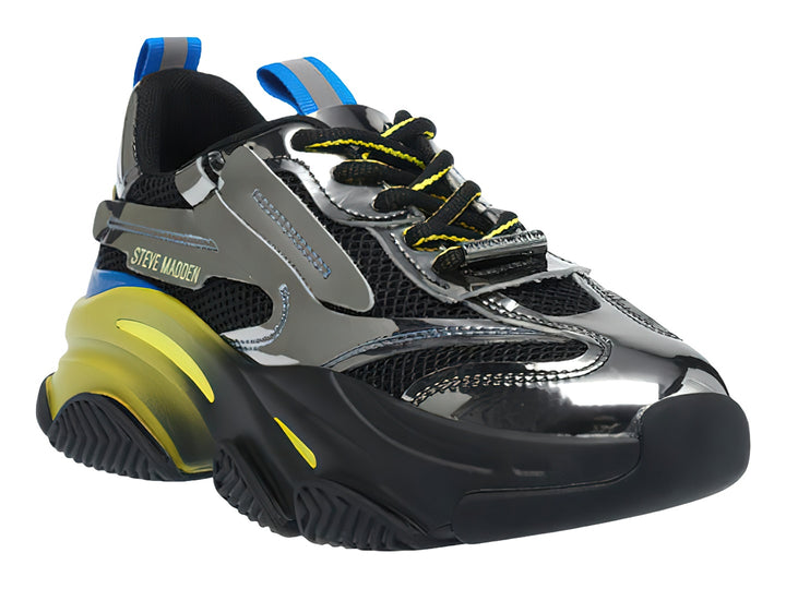 Tenis deportivos Steve Madden en color negro y plata con suela gruesa amarilla y detalles azules.