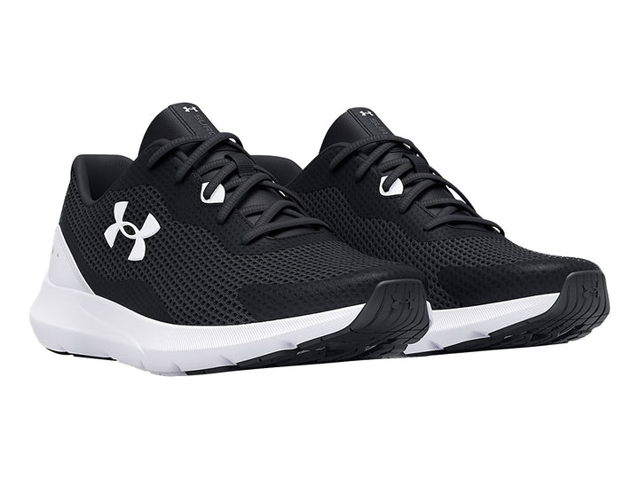 Tenis deportivos Under Armour Surge 3 en color negro con suela blanca y logotipo blanco lateral.