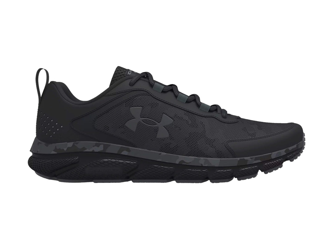 Tenis deportivos Under Armour Charged Assert 9 color negro con patrón de camuflaje en la entresuela.