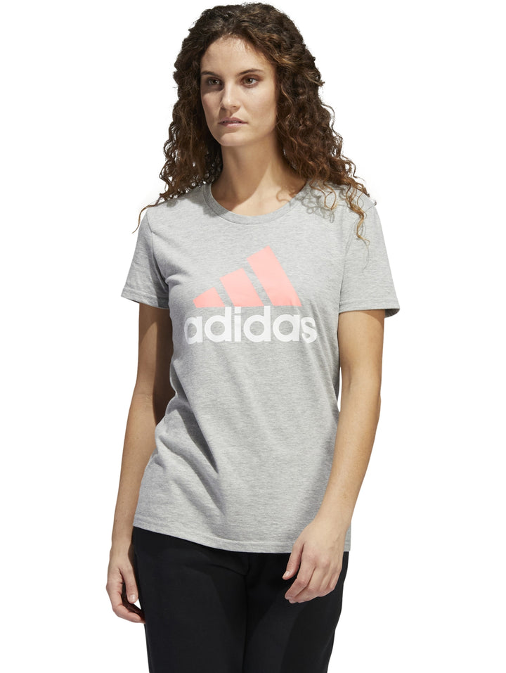Mujer vistiendo una camiseta deportiva Adidas de color gris con logotipo en el pecho.