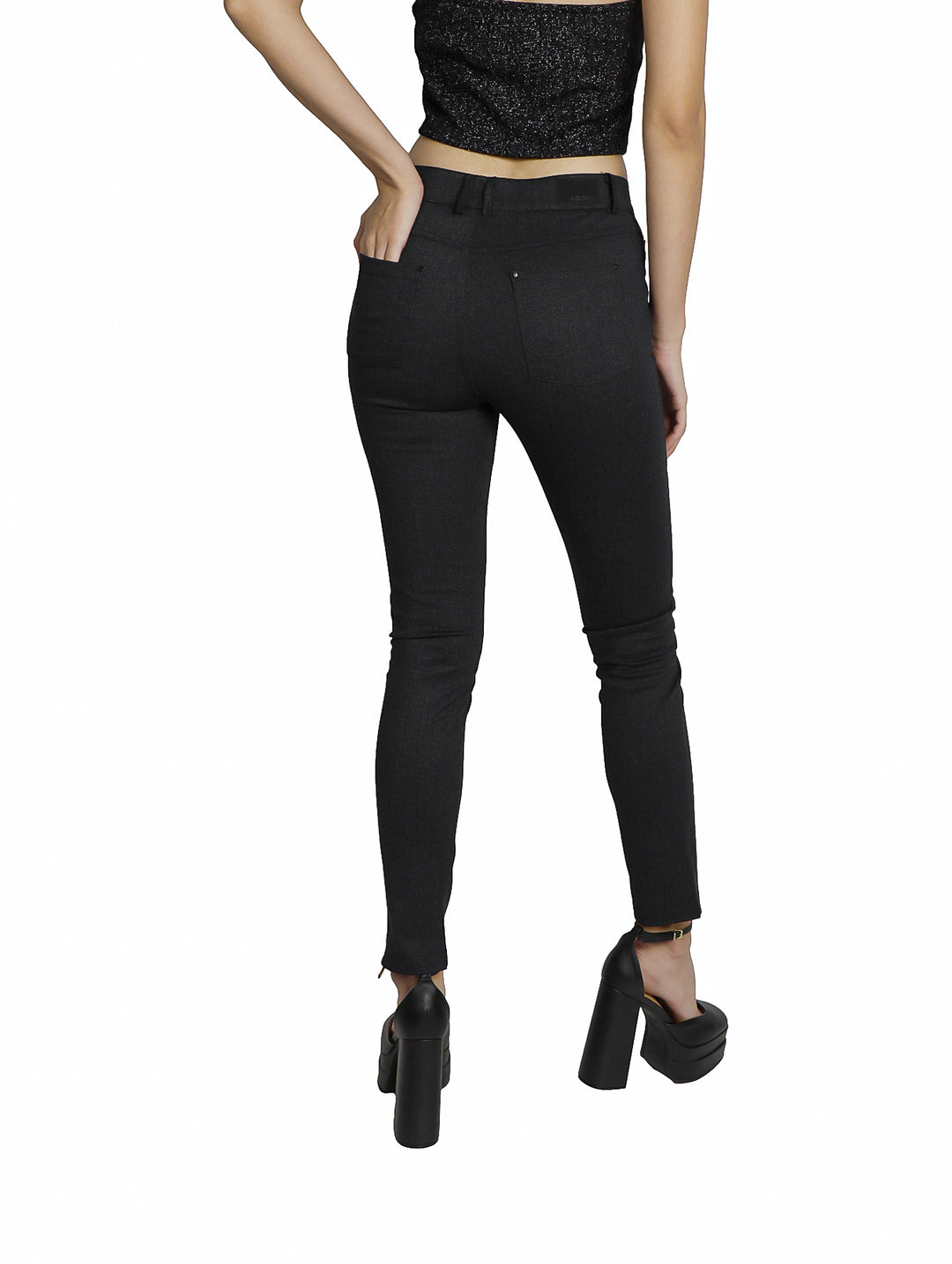 Mujer vistiendo un pantalón negro ajustado de interlock con zapatos de plataforma.