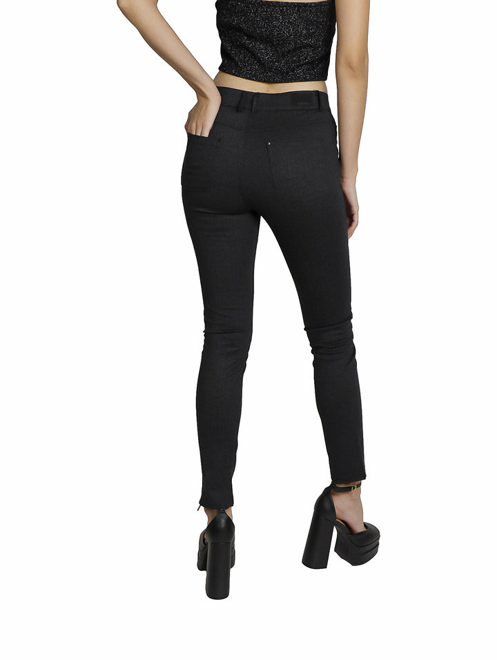Mujer vistiendo un pantalón negro ajustado de interlock con zapatos de plataforma.