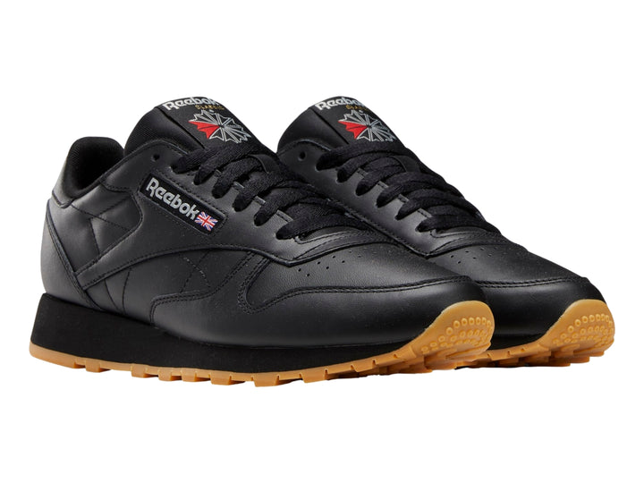 Tenis Reebok Classic Leather color negro con suela de goma marrón.