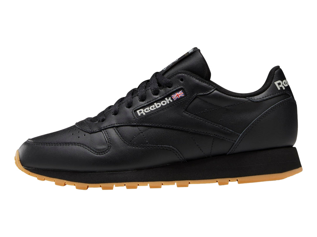Tenis Reebok Classic Leather color negro con suela de goma marrón.