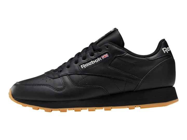 Tenis Reebok Classic Leather color negro con suela de goma marrón.