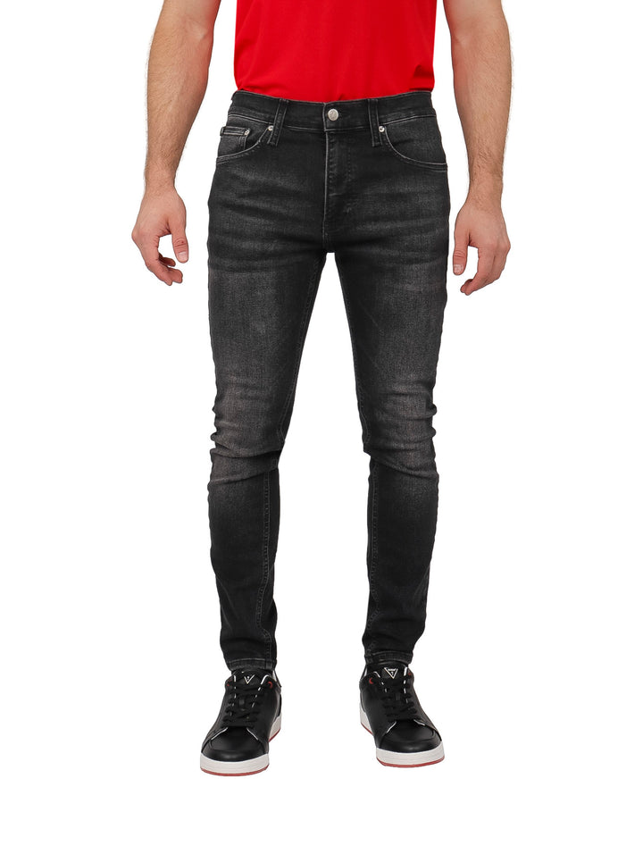 Hombre vistiendo pantalones jeans super skinny de color negro.