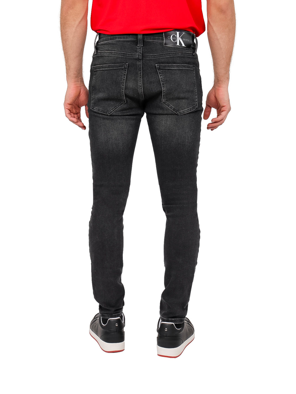 Hombre vistiendo pantalones jeans super skinny de color negro.