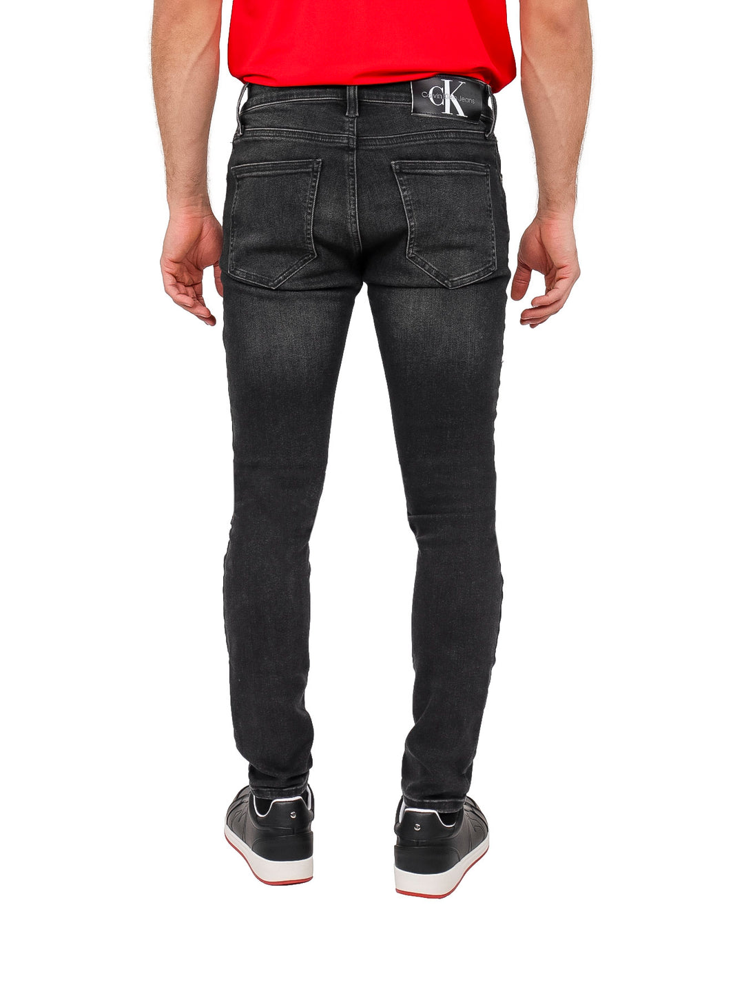 Hombre vistiendo pantalones jeans super skinny de color negro.
