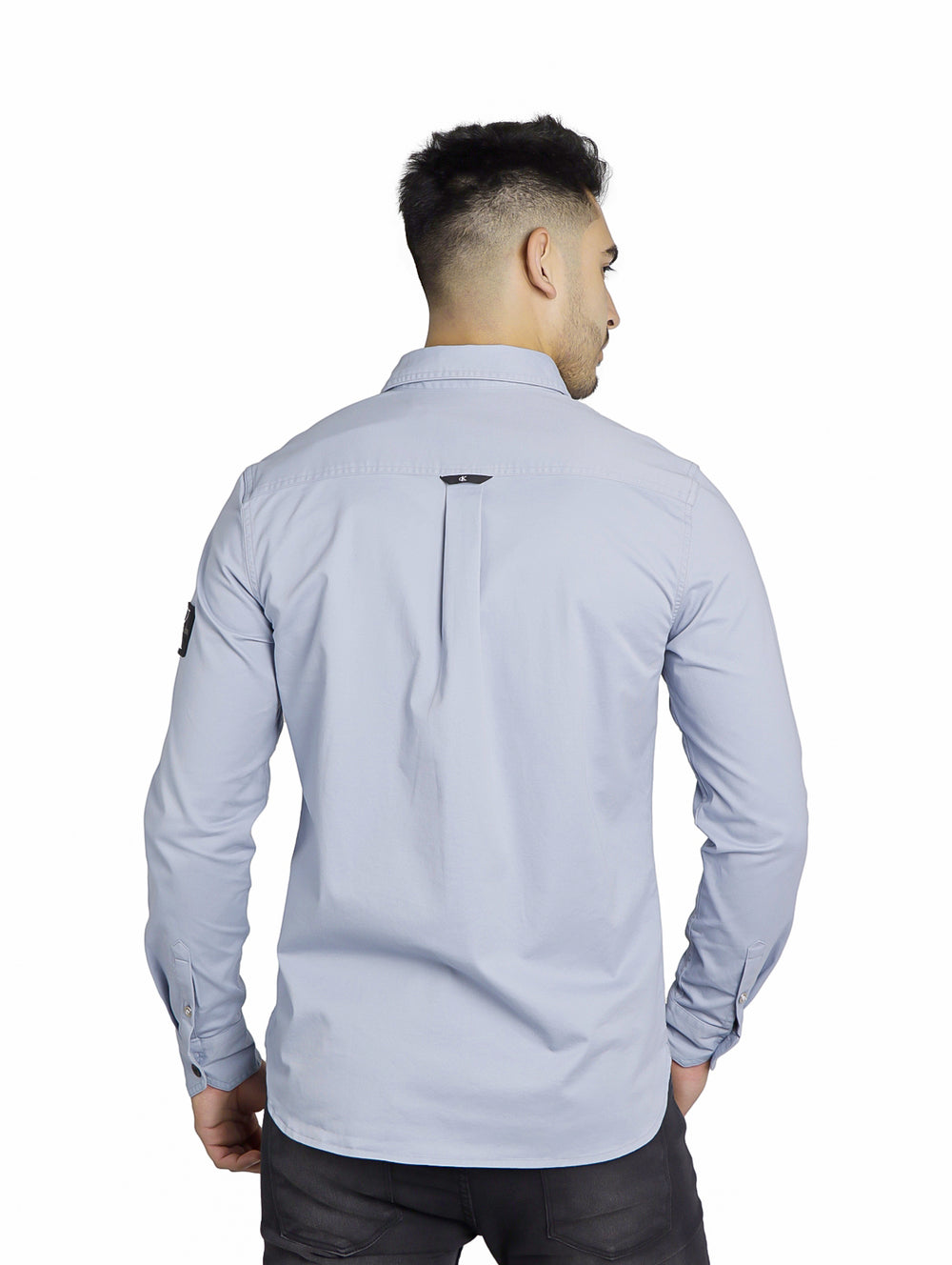 Hombre vistiendo una camisa Calvin Klein color Silver Sky de manga larga y cuello.