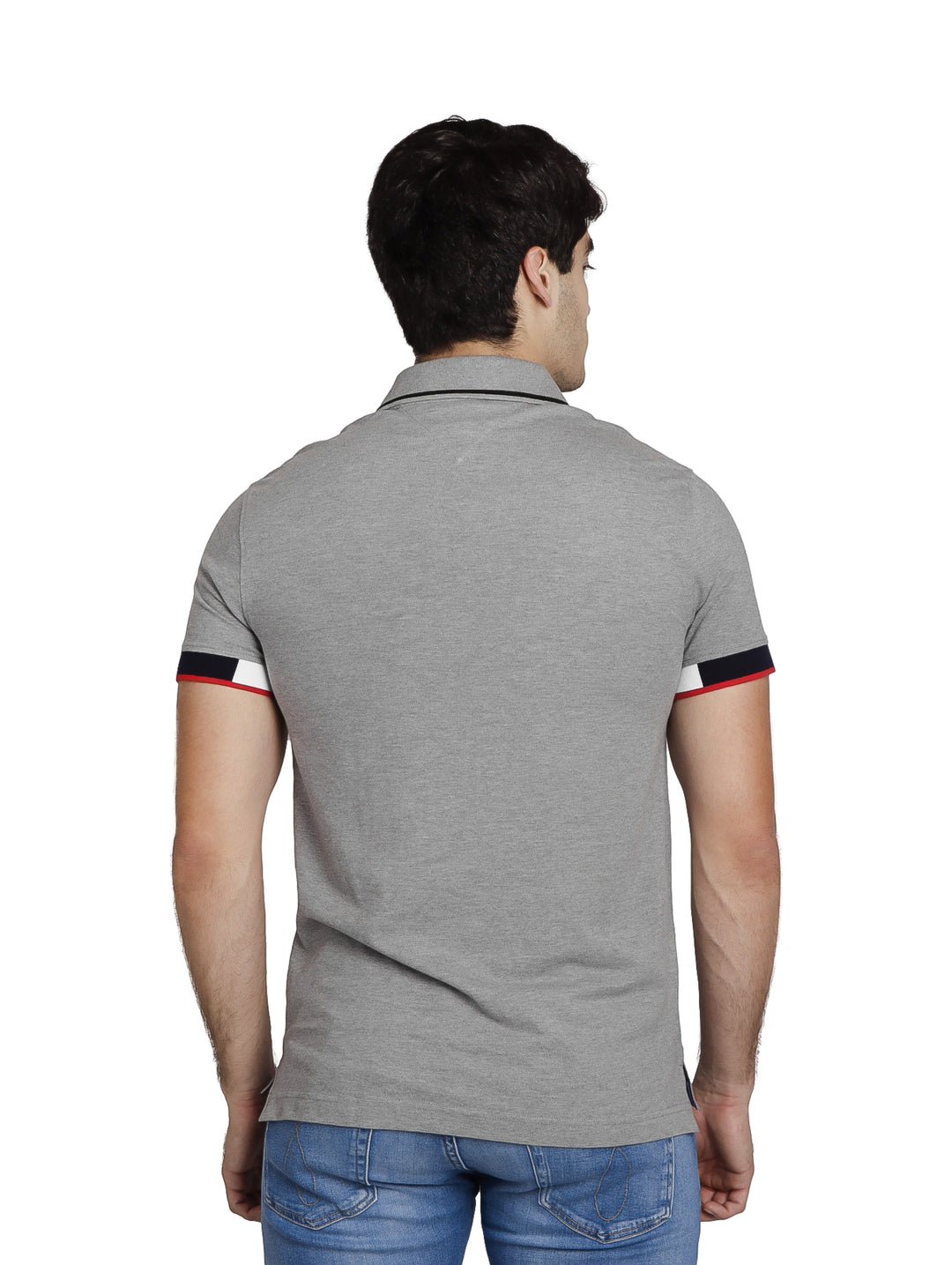 Hombre vistiendo polo Tommy Hilfiger color gris jaspeado con detalles tricolores en los puños y cuello.