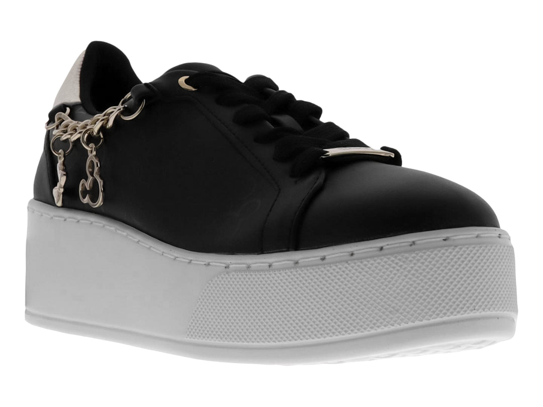 Tenis negros de plataforma con suela blanca y detalle de cadena dorada decorativa en el lateral.