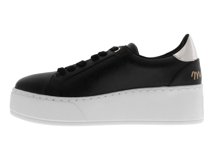 Tenis negros de plataforma con suela blanca y detalle de cadena dorada decorativa en el lateral.
