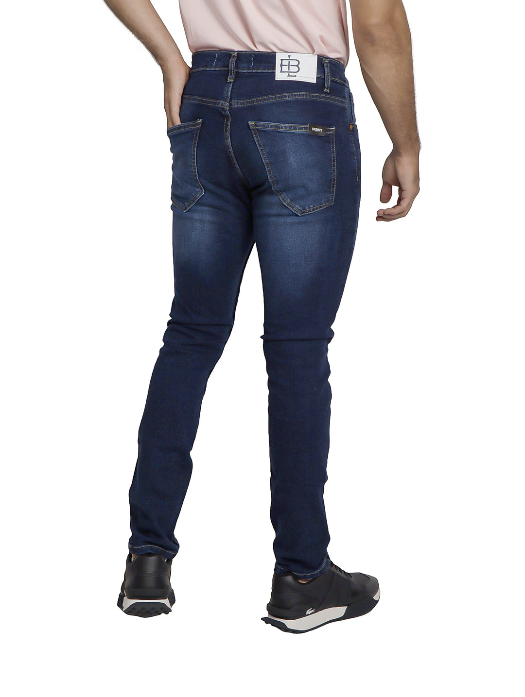 Hombre vistiendo pantalones jeans azul oscuro con efecto desgastado y corte ajustado.