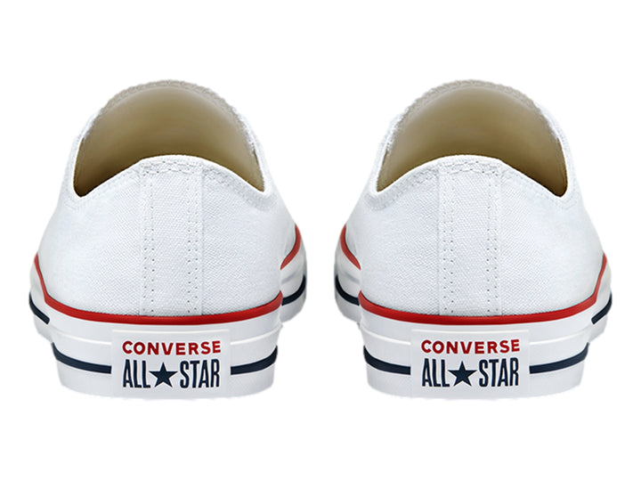 Tenis Converse blancos de lona con detalles en rojo y azul en la suela, diseño casual de corte bajo.