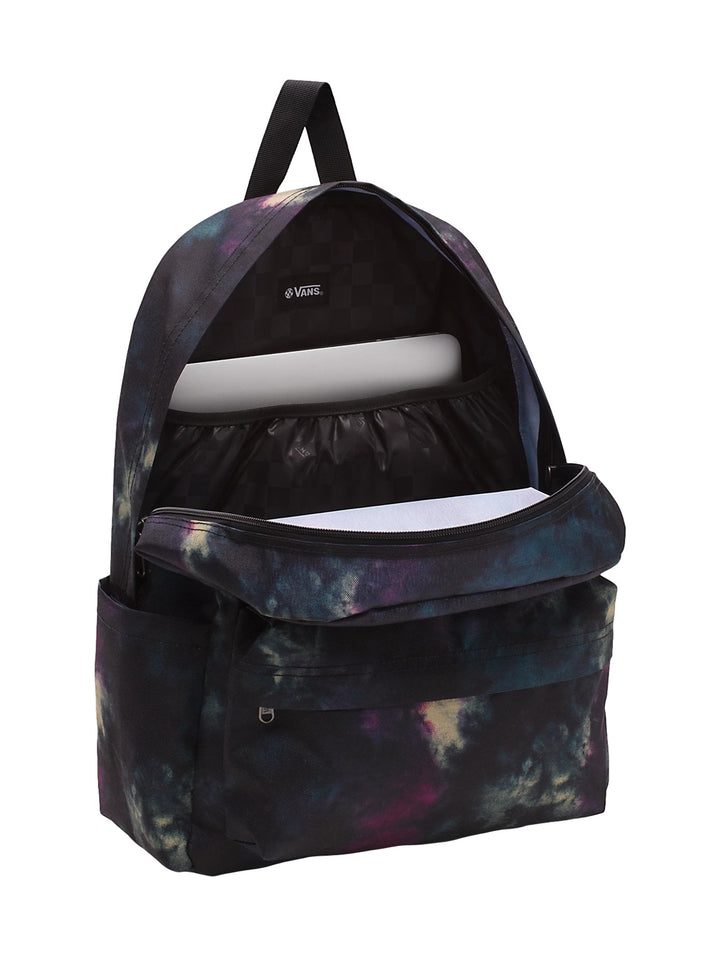 Mochila Vans con estampado multicolor estilo tie-dye en tonos negro, morado y azul, portada por una mujer.
