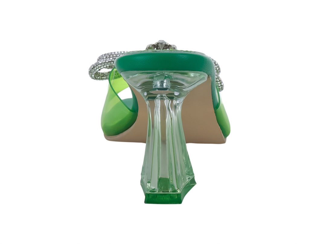 Sandalia de tacón alto color verde con moño de brillantes y tacón transparente.