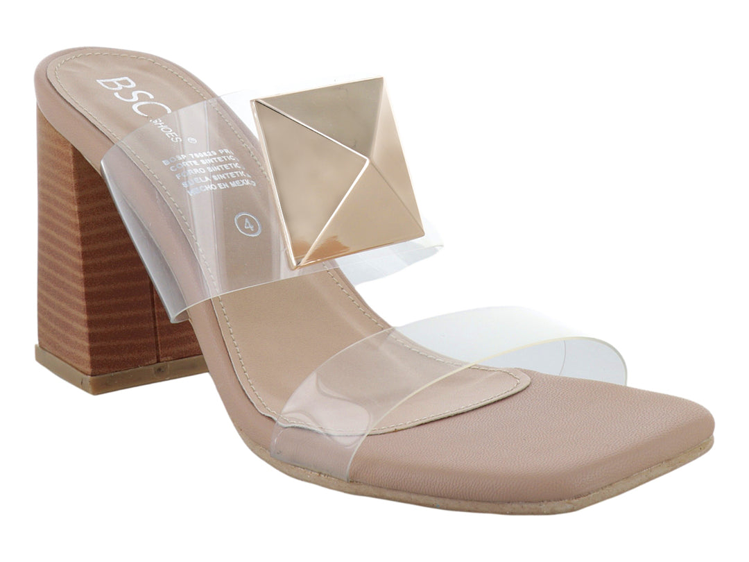 Sandalia de tacón cuadrado color beige con correas transparentes y un adorno geométrico dorado en la parte superior.
