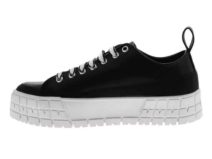 Tenis negros de plataforma con suela blanca gruesa y texto decorativo blanco en el lateral.