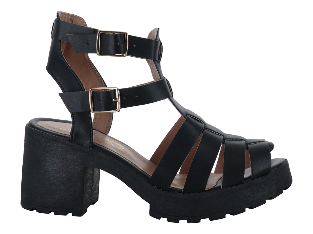 Sandalia negra de plataforma con tacón grueso, correas con hebillas doradas y suela track.