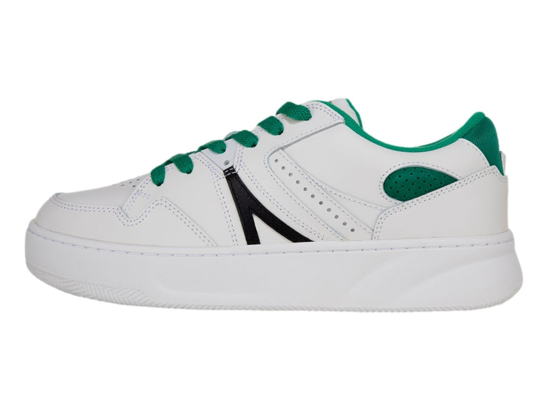 Tenis blancos Lacoste L005 con cordones y detalles en verde y una franja negra lateral.