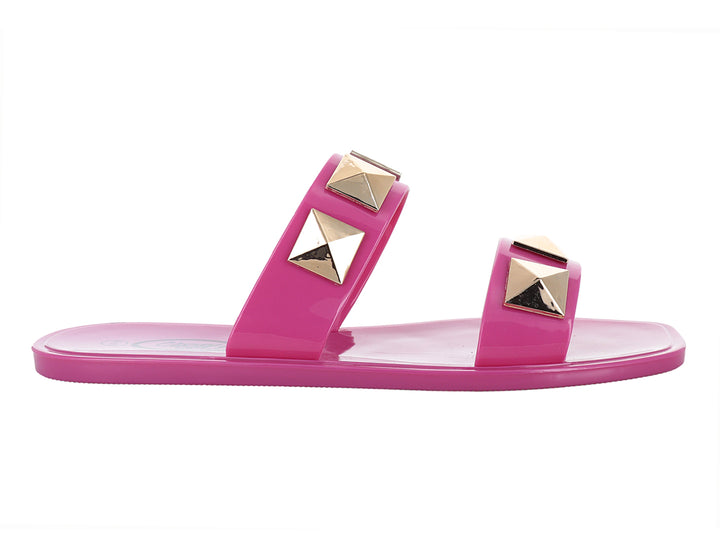 Sandalias fucsia brillante con tachuelas doradas en forma de pirámide.