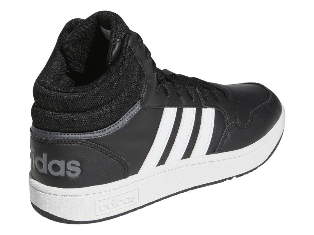 Tenis Adidas Hoops 3.0 Mid color negro con tres franjas blancas y suela blanca.