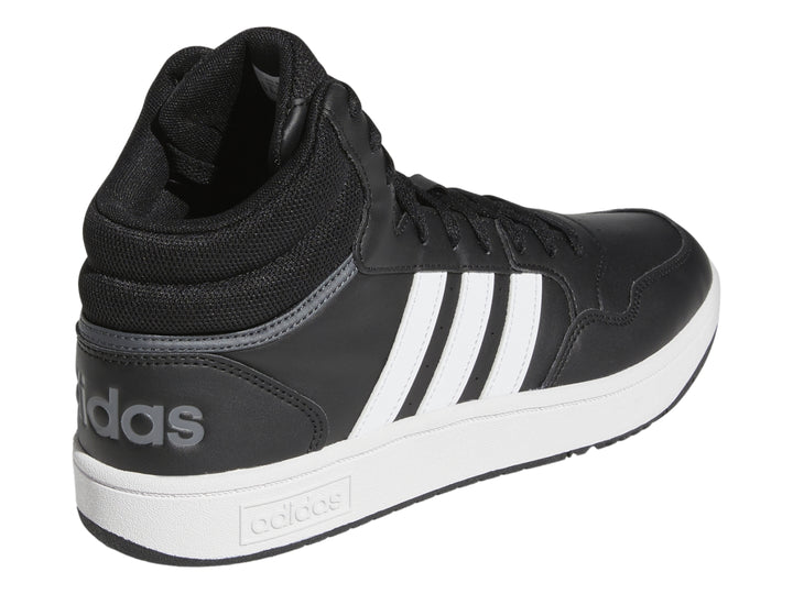 Tenis Adidas Hoops 3.0 Mid color negro con tres franjas blancas y suela blanca.