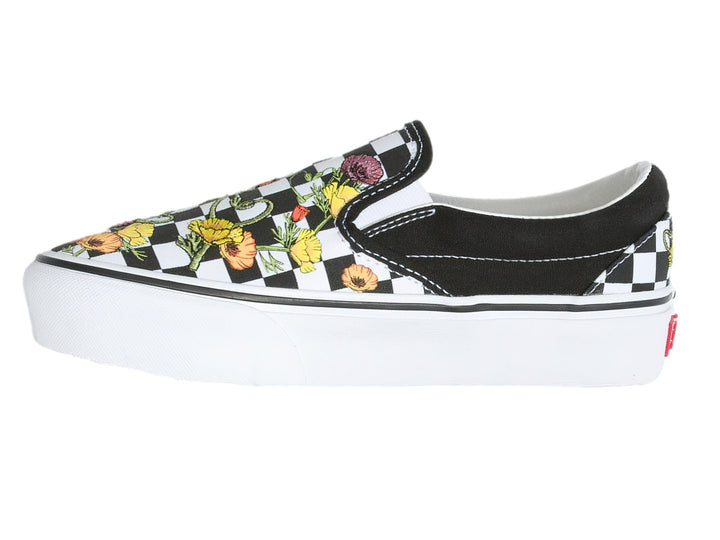 Tenis Vans Classic Slip-On negros con estampado de cuadros blancos y flores multicolores, suela blanca gruesa.