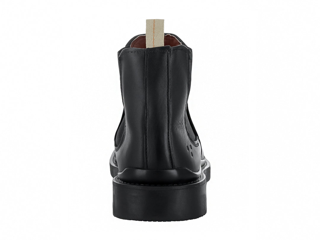 Bota Chelsea de color negro con suela gruesa y tirador beige en el talón.