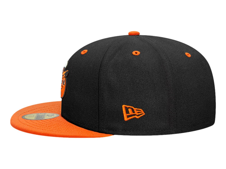 Gorra New Era color negro con visera naranja y un personaje bordado en el frente.