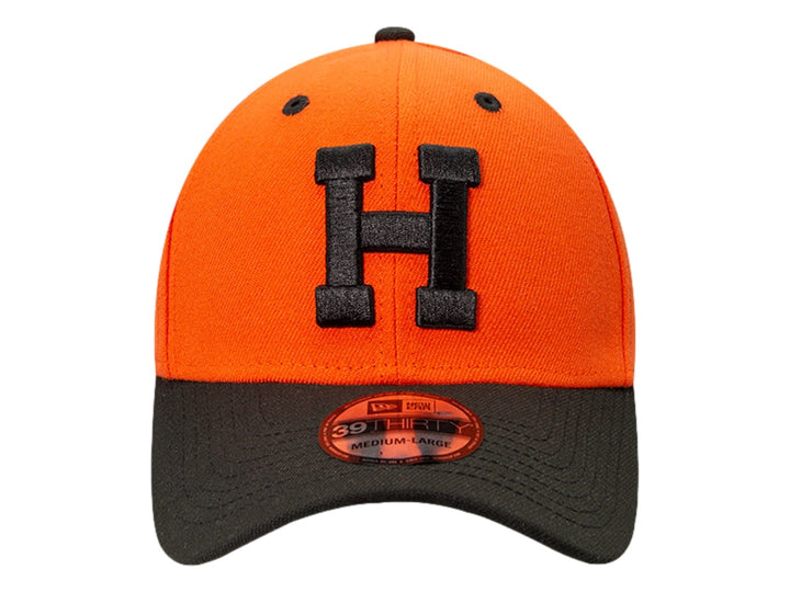 Gorra de béisbol New Era color naranja con visera negra y letra H bordada en el frente.