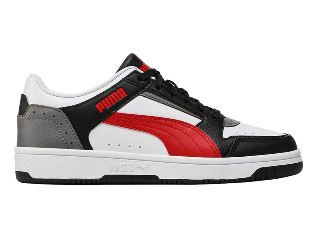 Tenis PUMA Rebound Joy Low en colores blanco, negro, rojo y gris con suela blanca.