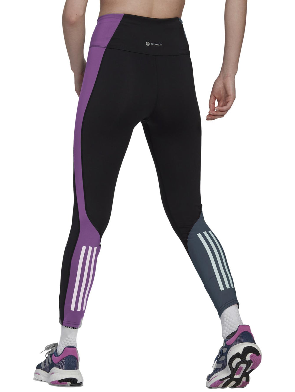Mallas deportivas Adidas negras con panel lateral morado y detalle gris en el tobillo.
