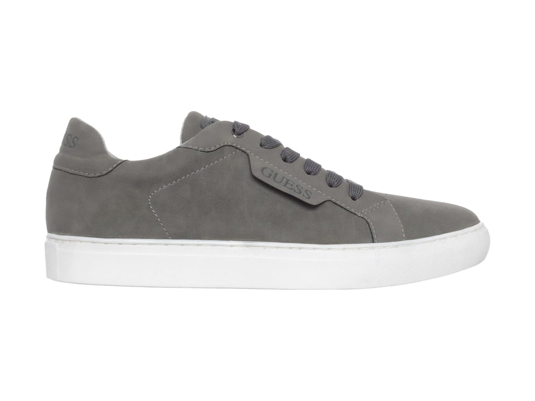 Tenis casuales Guess de color gris con suela blanca y agujetas a juego.