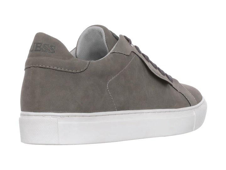 Tenis casuales Guess de color gris con suela blanca y agujetas a juego.